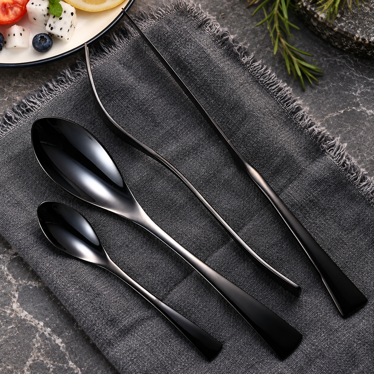 Eira black cutlery set detail with slim utensils on textured charcoal linen