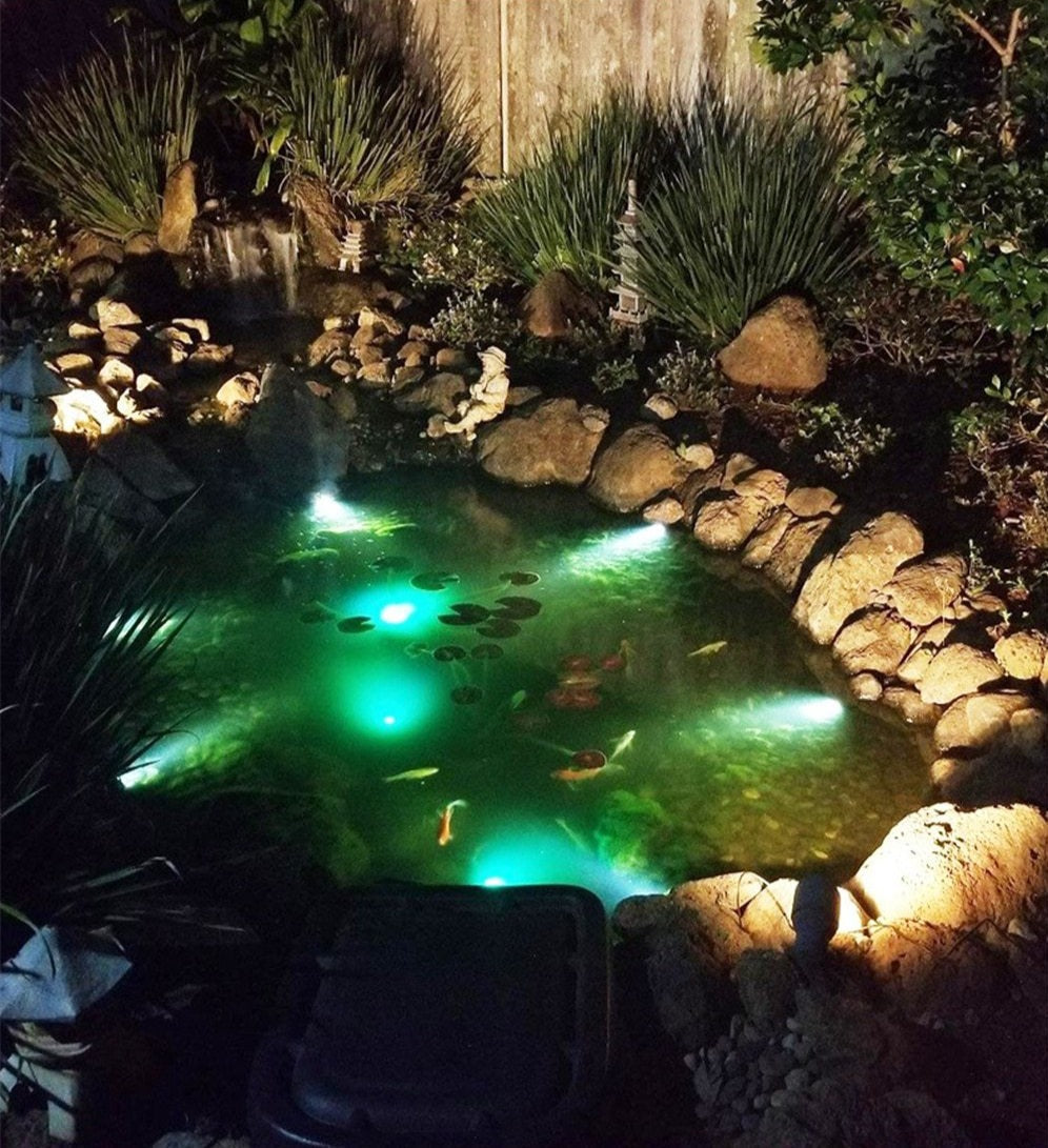 Runa multicolour solar lawn lights illuminating a landscaped garden pond at night