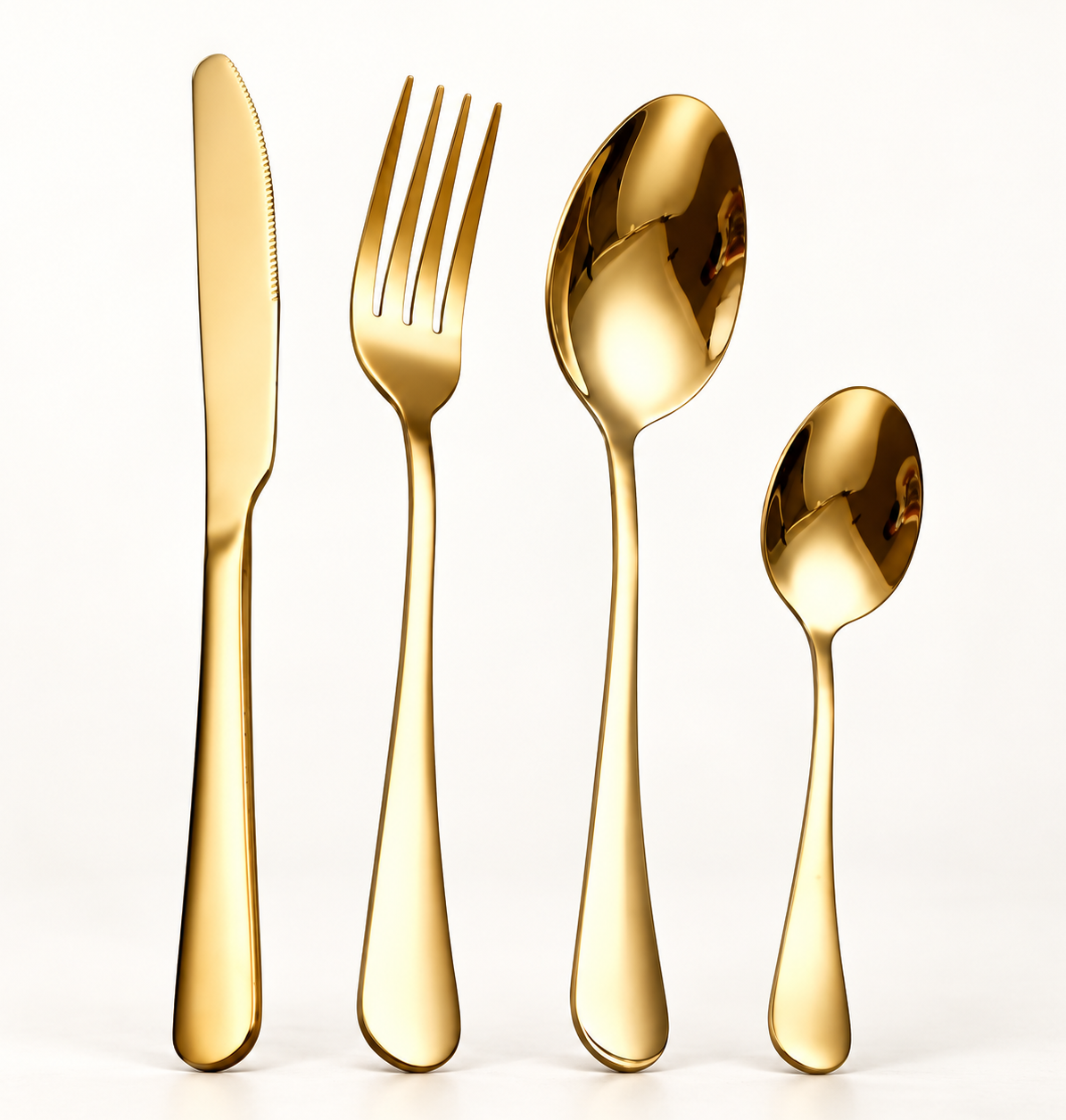 Tove gold stainless steel knife, fork, tablespoon and teaspoon on a warm white background