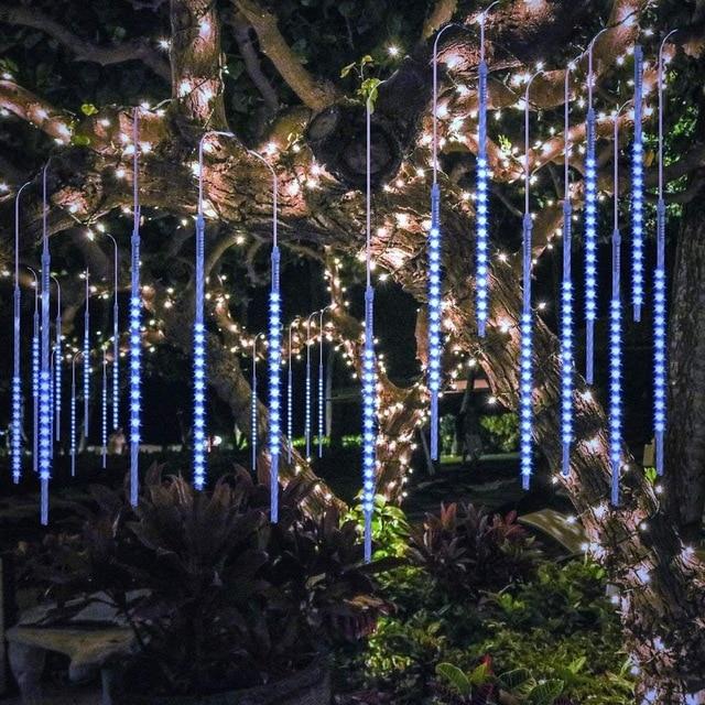 Blue and multicolor LED icicle tube lights hanging in a garden tree