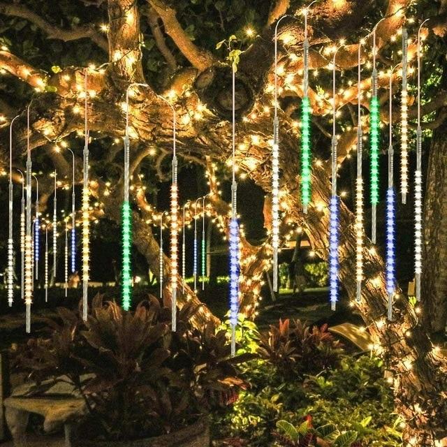 Multicolor LED icicle tube lights hanging in a garden tree
