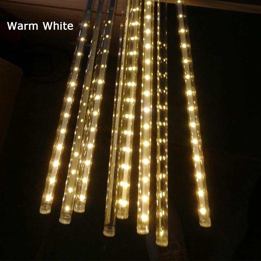Eight warm white LED icicle tubes glowing in a close-up