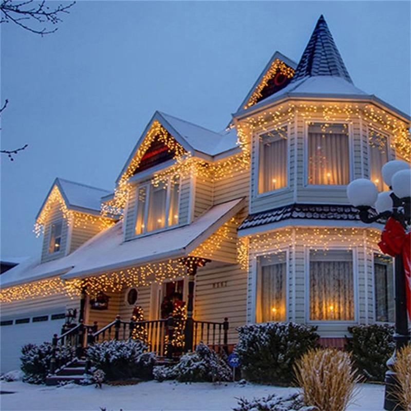 Ylva warm white LED curtain lights decorating a snow-covered house exterior