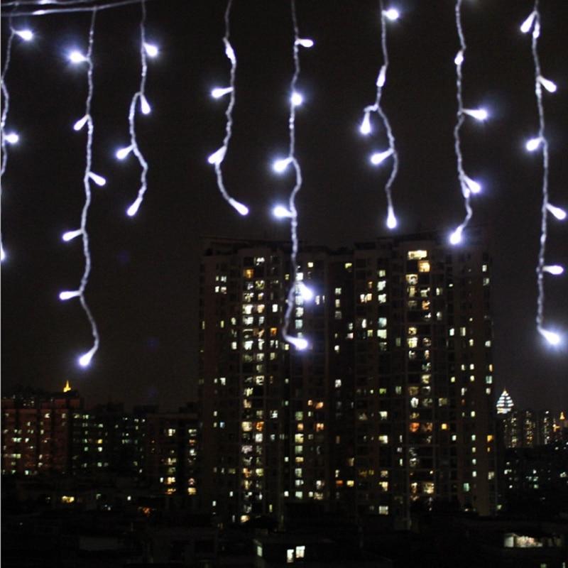 Ylva white LED curtain lights hanging from a balcony above a city skyline