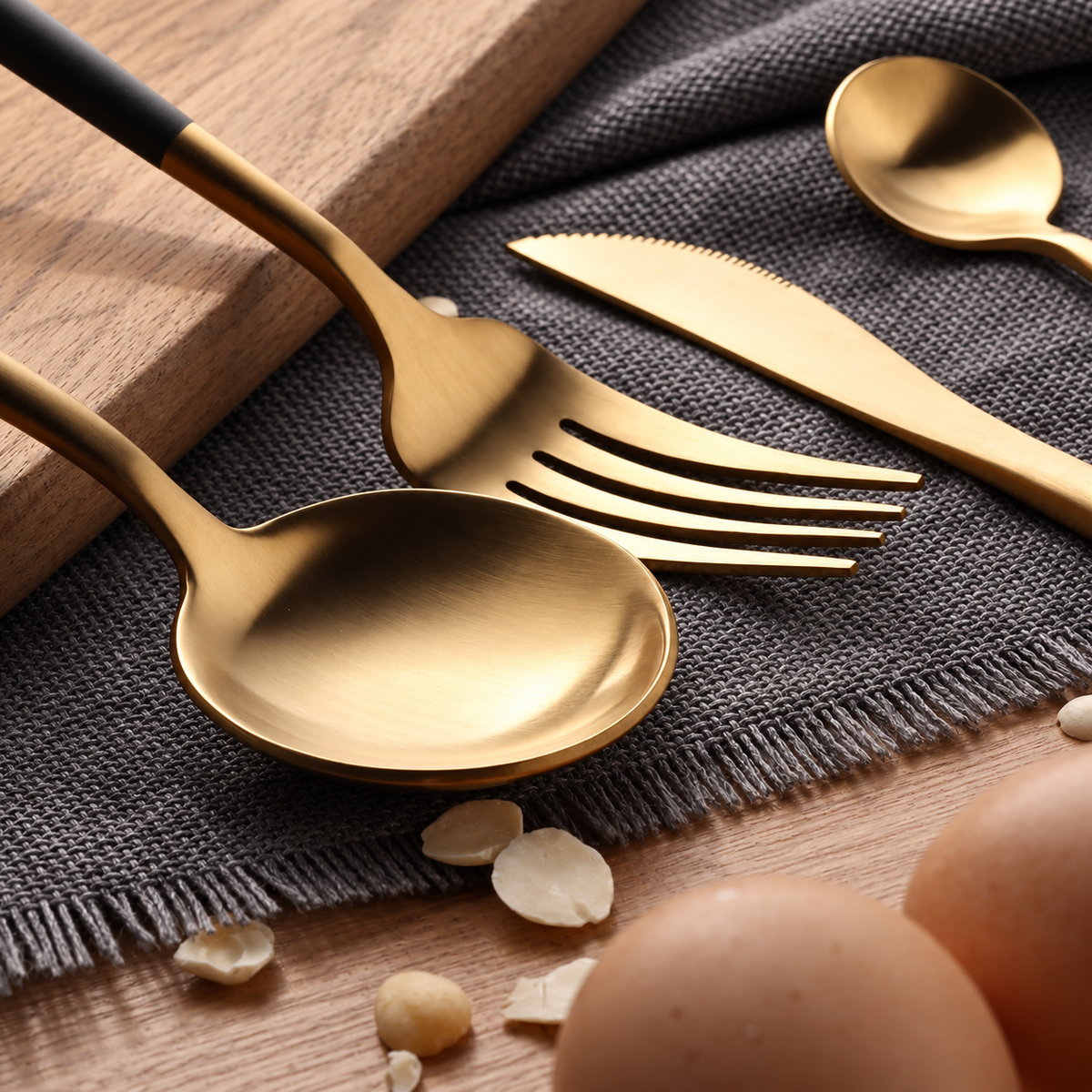 Astrid gold and black flatware close-up showing spoon, fork and knife heads