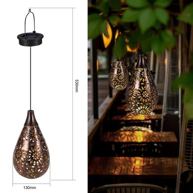 Solar droplet hanging garden lamp dimensions beside two lamps glowing in a leafy garden