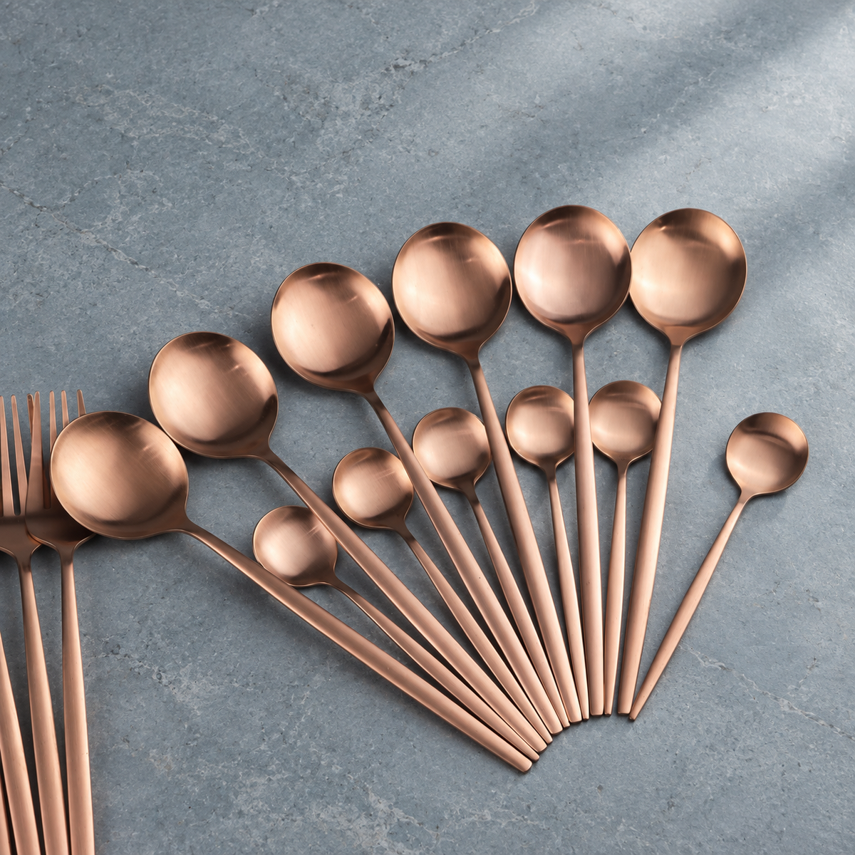 Lykke rose gold stainless flatware spoon detail on blue-grey stone
