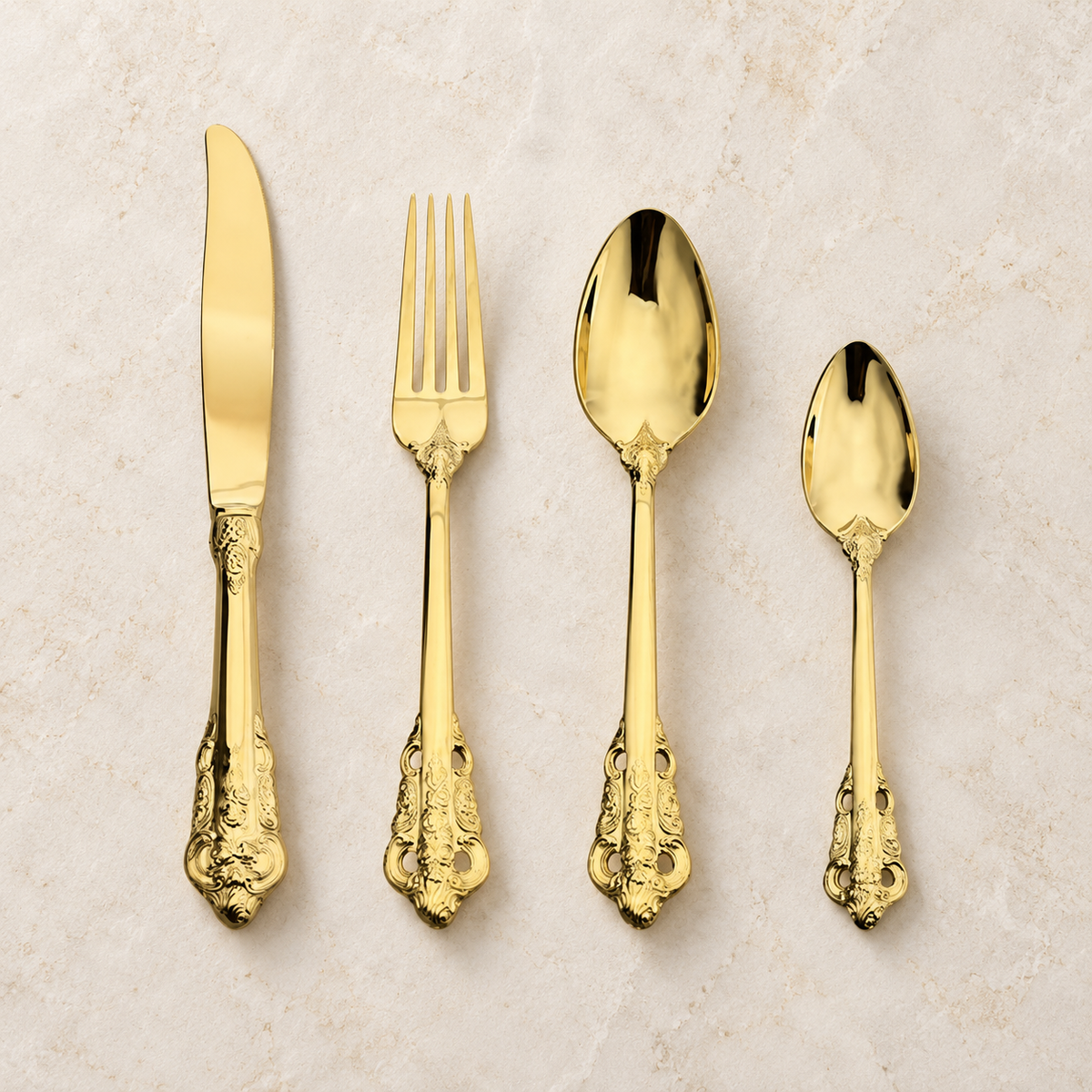 Solva gold vintage cutlery set with ornate handles on an ivory background