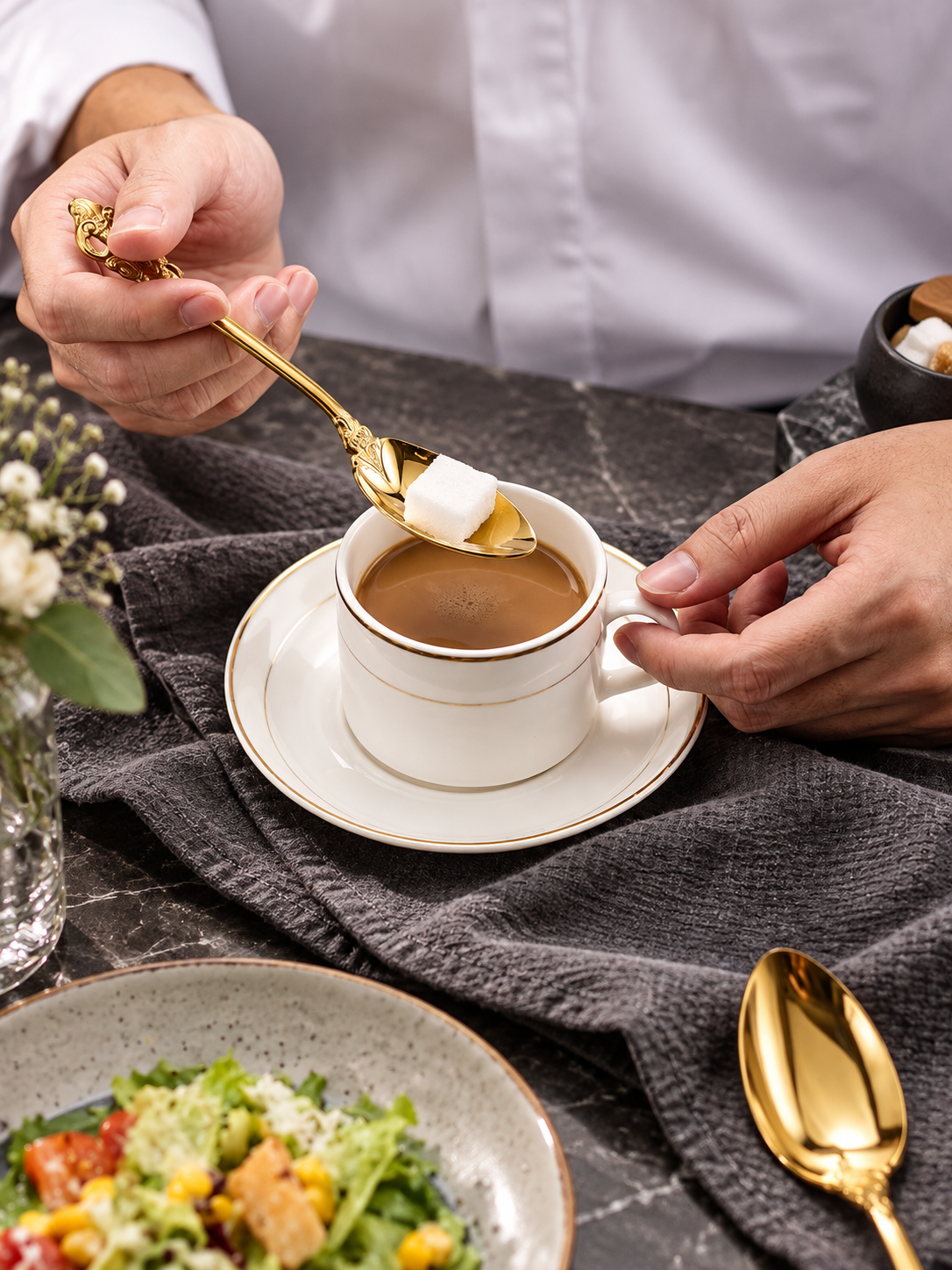 Solva gold teaspoon stirring coffee at a classic table setting
