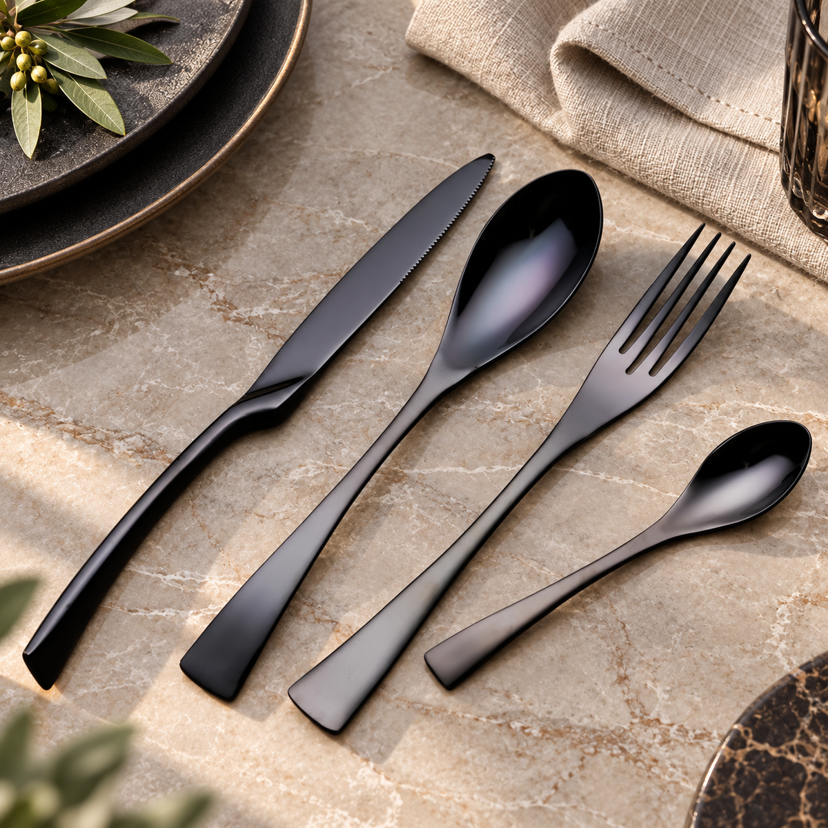Vidar black metal cutlery set with knife, fork, tablespoon and teaspoon on a stone dining table