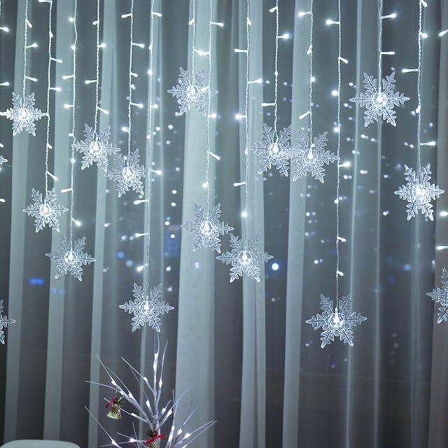Torun snowflake LED string lights in cold white hanging across sheer curtains