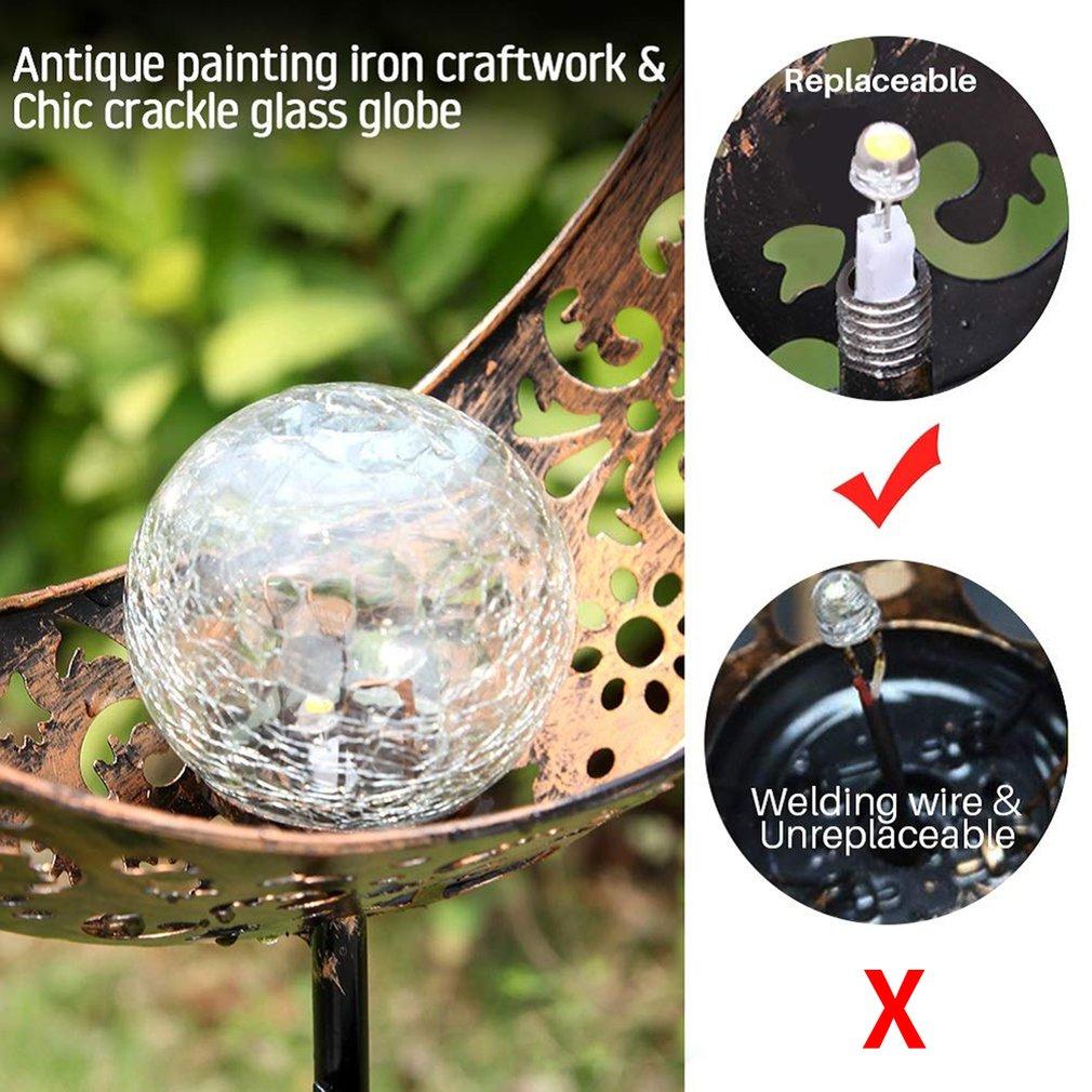 Solar crescent moon garden stake close-up showing crackle-glass globe and replaceable LED