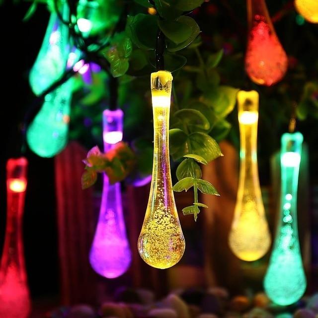 Sigrid multicolor solar droplet string lights glowing among garden leaves