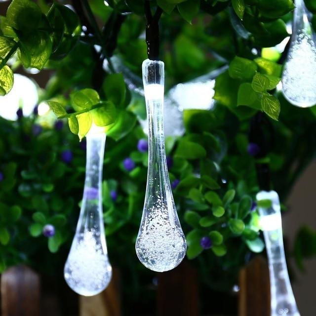 Sigrid white solar droplet string lights glowing among green leaves