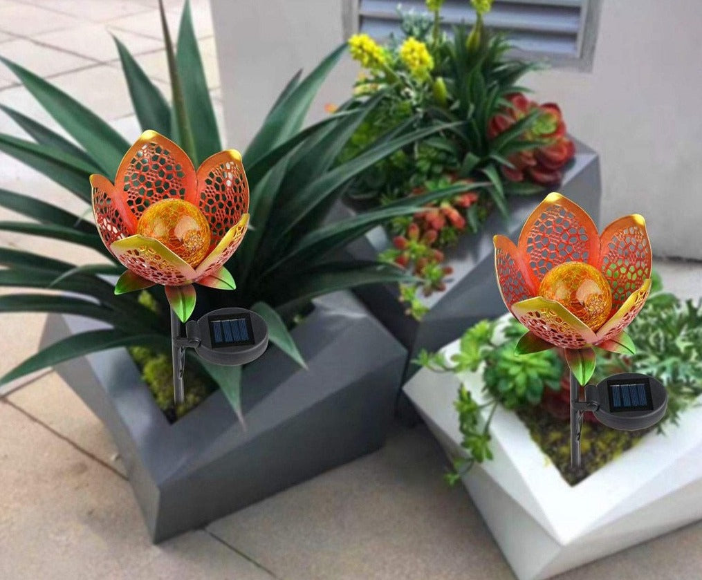 Idun gold flower stake lights in modern planters with visible solar panels