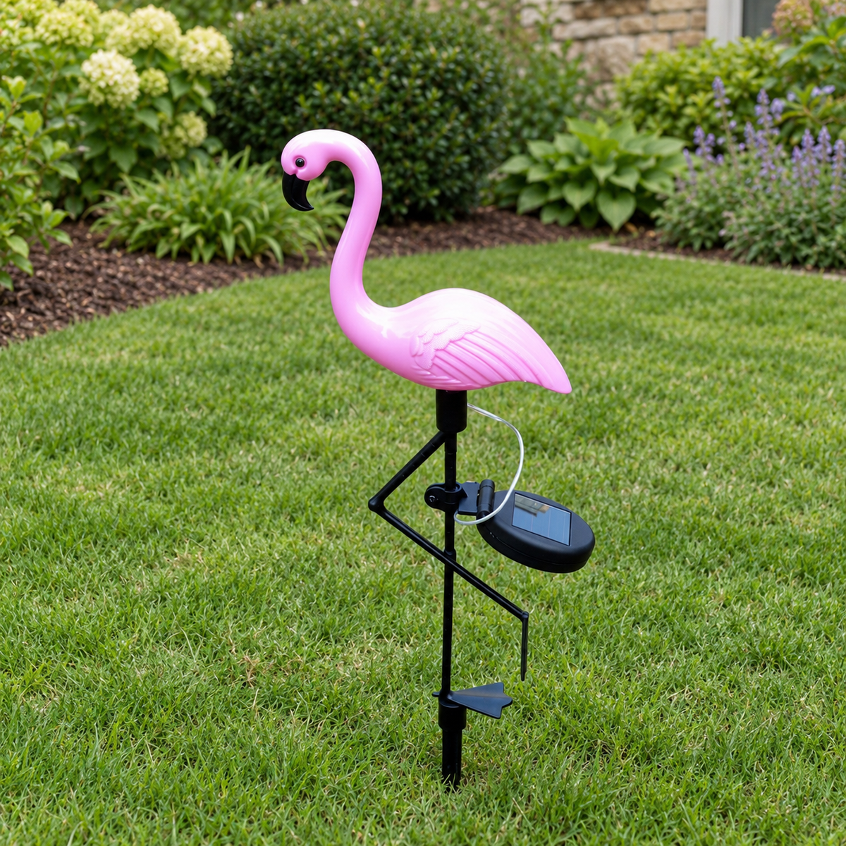 Single solar flamingo garden stake light with panel and black support frame on lawn