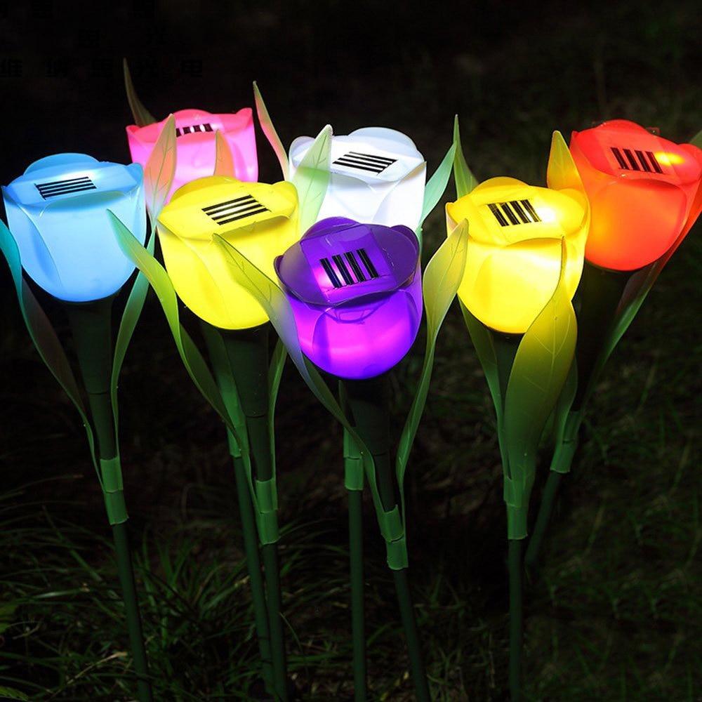 Solar tulip garden stake lights in eight bright colors glowing in grass at night