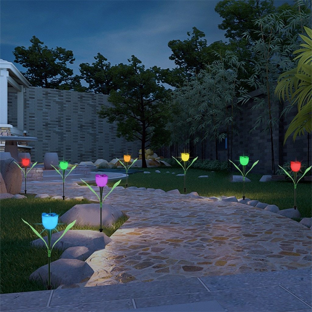 Multicolor solar tulip garden stake lights lining a stone garden path at dusk