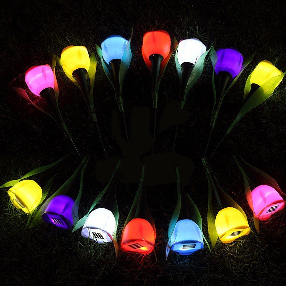 Multicolor solar tulip garden stake lights arranged in a glowing circle on grass at night